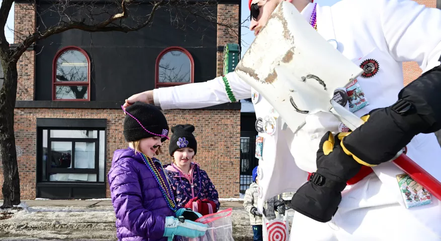 Marirenn Osborne, 6 1/4 years-old, gets a string of beads from a Winter Carnival Tux Team-Pooper Scooper during the 2022 King Boreas Grande Day Parade, Presented by Hamernick’s along West 7th Street in St. Paul on Saturday, January 29, 2022. (John Autey / Pioneer Press)