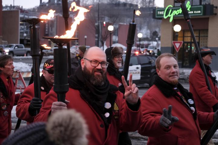 St. Paul community members make the “V” hand gesture as they proclaim allegiance to Vulcanus Rex during their march in the Torchlight parade during the winter carnival in downtown St. Paul on Feb. 4, 2023. The parade symbolizes Vulcanus Rex’s march on the ice castle to take the throne from King Boreas, a legend made into tradition every year at St. Paul’s winter carnival. (Bryson Rossell / Pioneer Press)