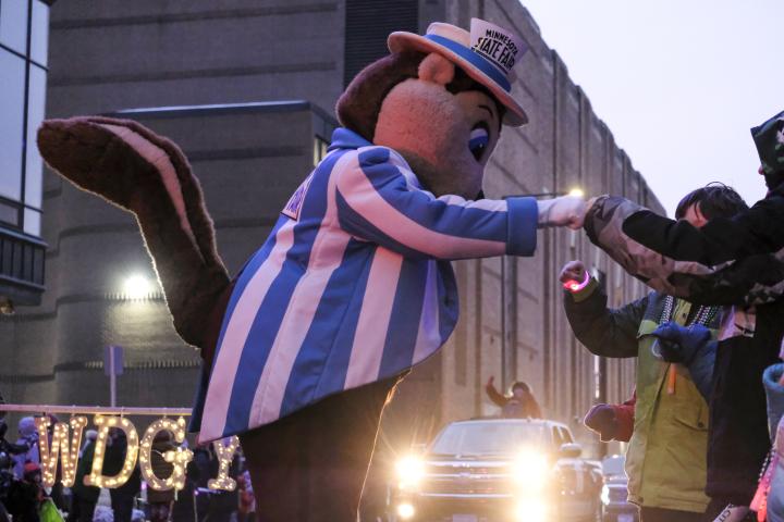 The mascot of the Minnesota State Fair joins the Vulcan Krewe in the torchlight parade in downtown St. Paul and gives fist bumps to onlookers on Feb. 4, 2023. The torchlight parade symbolizes Vulcanus Rex’s march on the ice castle to take the throne from King Boreas, a legend made into tradition every year at St. Paul’s winter carnival. (Bryson Rossell / Pioneer Press)
