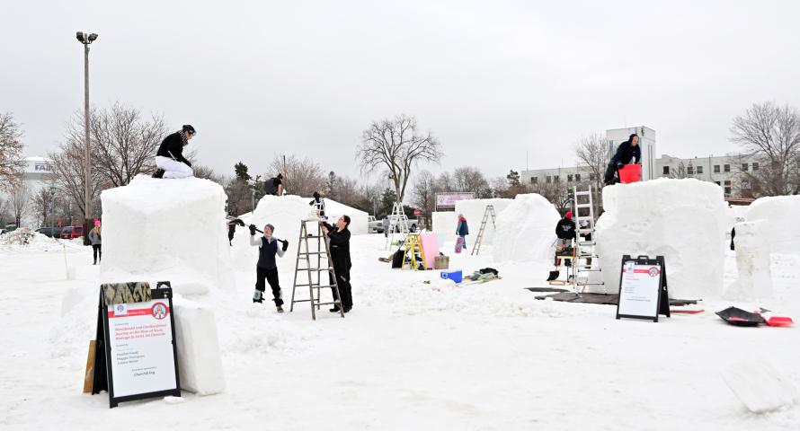Teams work at carving their blocks of snow in the snow sculpture competition, part of the St. Paul Winter Carnival, at the Minnesota State Fairgrounds in Falcon Heights on Friday, Jan. 26, 2024. (John Autey / Pioneer Press)
