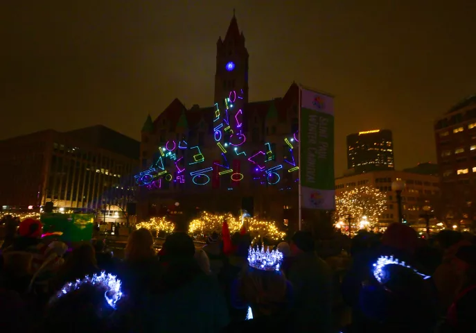 Three junior Winter Carnival princess wearing glowing tiaras watch a laser light show dance on the Landmark Center across the street from Rice Park in St. Paul as part of the St. Paul Winter Carnival-Light the Park celebration to mark the official start the 2024 “The Coolest Celebration on Earth” on Thursday, Jan. 25, 2024. (John Autey / Pioneer Press)