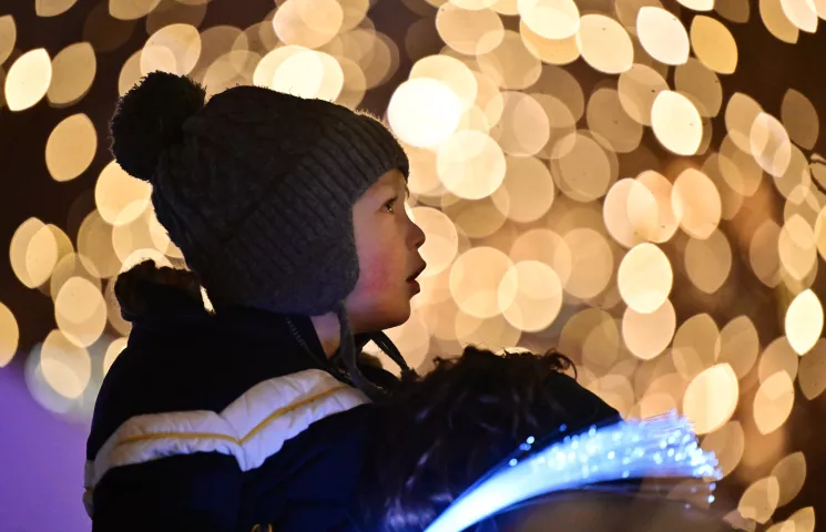 Louis Bielenberg, 2, from St. Paul, watches a laser light show dance on the Landmark Center across the street from Rice Park in St. Paul as part of the St. Paul Winter Carnival-Light the Park celebration to mark the official start the 2024 “The Coolest Celebration on Earth” on Thursday, Jan. 25, 2024. (John Autey / Pioneer Press)