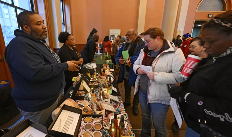 Jervis White sells sauces and seasonings at his Black Roots table during the St. Paul Winter Carnival’s Rondo Night at the Landmark Center in downtown St. Paul on Thursday, Feb. 2, 2023. (John Autey / Pioneer Press)