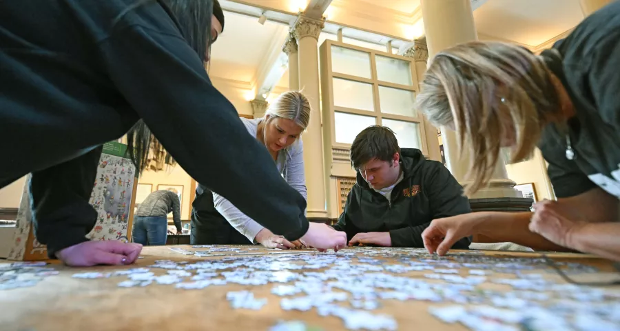 (From left) Family friend Nicole Schmitz, Emily Kutzler, Joshua Doss and mom to Emily and Joshua, Betty Doss, all from Pillager, Minnesota work their puzzle at the 2023 Winter Carnival Jigsaw Puzzle Contest at Landmark Center in St. Paul on Saturday, Jan. 28, 2023. (John Autey / Pioneer Press)