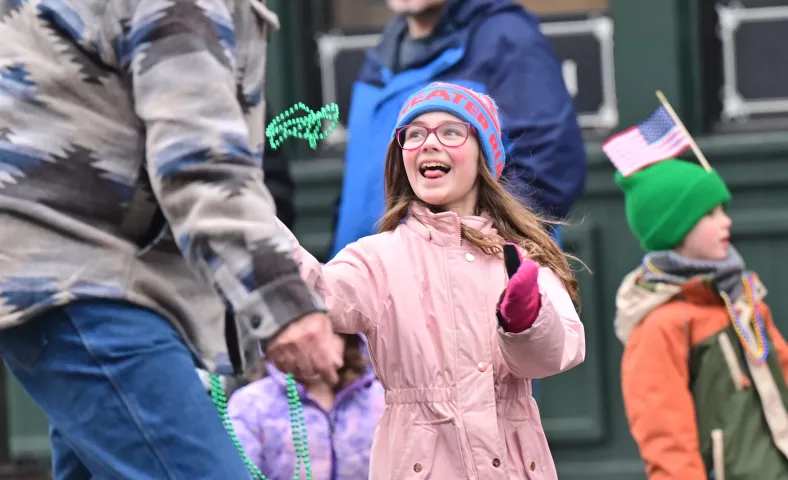 Charlotte Colt, 10 laughs, as she catches a string of beads from a member of the order of the West Wind the during the 2024 St. Paul Winter Carnival King Boreas Grande Day Parade along West 7th Street in downtown on Saturday, Jan. 27, 2024. (John Autey / Pioneer Press)