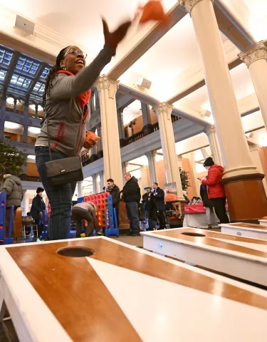 Juliet Mitchell toss a beanbag as she plays corn hole during the St. Paul Winter Carnival’s Rondo Night at the Landmark Center in downtown St. Paul on Thursday, Feb. 2, 2023. (John Autey / Pioneer Press)