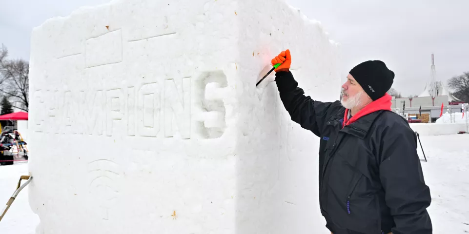 David White from Elk River carves out the letters on a snow sculpture honoring the Minnesota Twins 2023 Central Division championship at the Vulcan Snow Park at the Minnesota State Fair Grounds in Falcon Heights on Friday, Jan. 26, 2024. (John Autey / Pioneer Press)