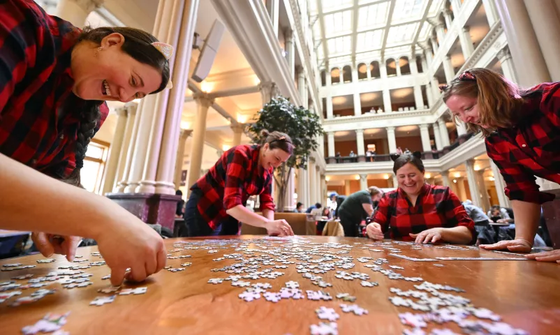 The family and friend team of (from left) Jill Derouin, from Minneapolis, Laura Scott from St. Paul, Janae Derouin from Detroit Lakes and Emily Mehr-Kodada from Marine on St. Croix work to put their puzzle together at the 2023 Winter Carnival Jigsaw Puzzle Contest at Landmark Center in St. Paul on Saturday, Jan. 28, 2023. (John Autey / Pioneer Press)