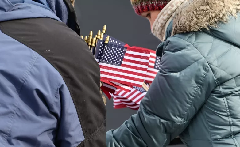Volunteers gather up small American flags to pass out at the 2023 Winter Carnival Grande Day Parade in downtown St. Paul on Saturday, Jan. 28, 2023. (John Autey / Pioneer Press)