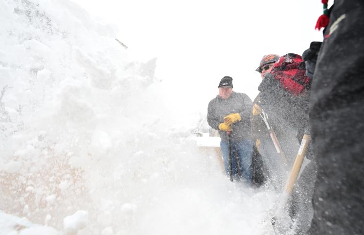 Volunteers brace themselves for a wintry torrent as they receive another load of snow during the “Snow Stomp” at the St. Paul Winter Carnival’s Vulcan Snow Park at the Minnesota State Fair grounds on Saturday, Jan. 21, 2023. Snow is loaded into 8 x 8 x 8 foot cubes and packed down in preparation for snow carving competition later in the week. The stomping goes on all weekend as the volunteers build 23 blocks for 15 professional snow carving teams and 8 amateur crews. (John Autey / Pioneer Press