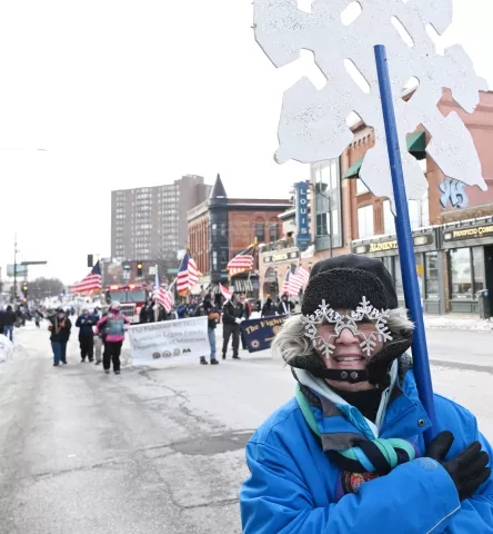 A snowflake bearer with festive glasses marches in the 2023 Winter Carnival Grands Day Parade in downtown St. Paul on Saturday, Jan. 28, 2023. (John Autey / Pioneer Press)