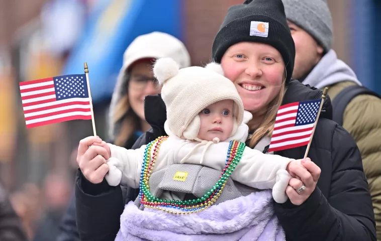 Malone Johnson, 10 months, held by her mom Suzette, from St. Paul, watches her first King Boreas Grande Day Parade on Saturday, Jan. 27, 2024. (John Autey / Pioneer Press)