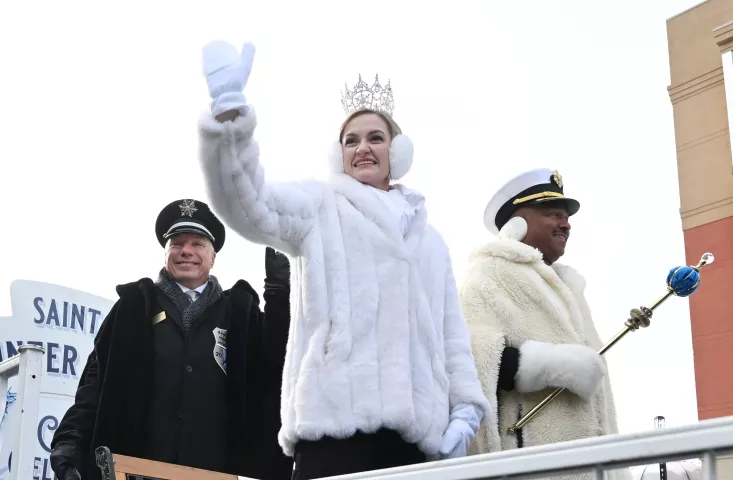 Liv Swenson, 2023 Aurora, Queen of the Snows, waves to the crowds at the 2023 Winter Carnival Grande Day Parade in downtown St. Paul on Saturday, Jan. 28, 2023. Behind Aurora is Prime Minister Gary Schaak, left and Boreas Rex LXXXVI, Leo E. Lewis. (John Autey / Pioneer Press)
